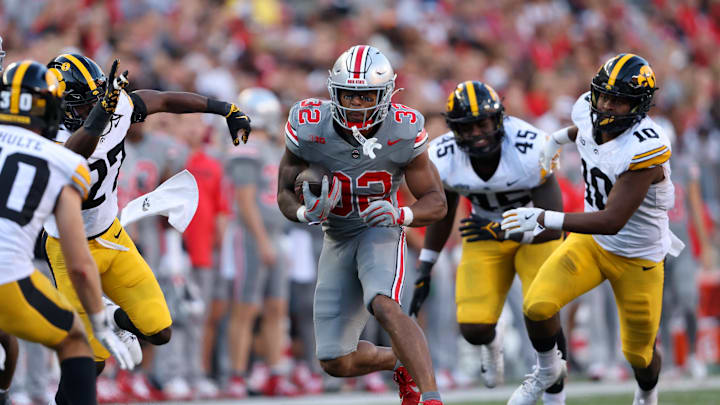 Oct 5, 2024; Columbus, Ohio, USA; Ohio State Buckeyes running back TreVeyon Henderson (32) runs the ball against Iowa Hawkeyes linebacker Nick Jackson (10) and defensive back Jermari Harris (27) during the fourth quarter at Ohio Stadium. Mandatory Credit: Joseph Maiorana-Imagn Images