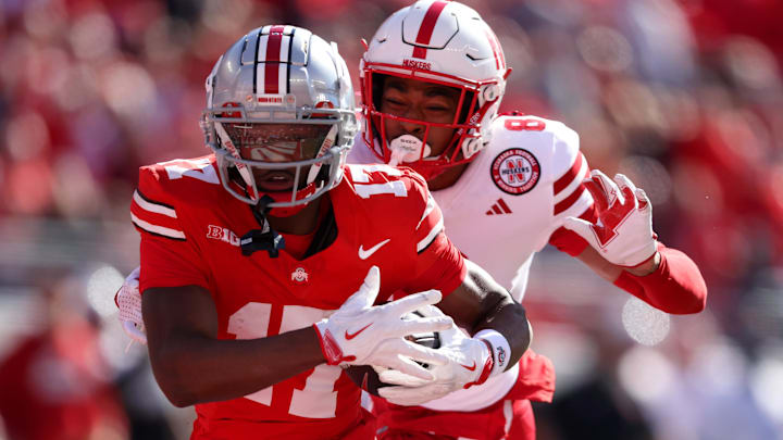 Oct 26, 2024; Columbus, Ohio, USA; Ohio State Buckeyes wide receiver Carnell Tate (17) catches a touchdown pass as Nebraska Cornhuskers defensive back Malcolm Hartzog Jr. (7) defends during the first quarter at Ohio Stadium. Mandatory Credit: Joseph Maiorana-Imagn Images
