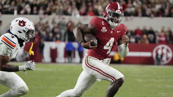 Nov 30, 2024; Tuscaloosa, Alabama, USA;  Alabama Crimson Tide quarterback Jalen Milroe (4) runs for a touchdown against Auburn Tigers cornerback Kayin Lee (4) during the second half at Bryant-Denny Stadium. Alabama won 28-14. Mandatory Credit: Gary Cosby Jr.-Imagn Images