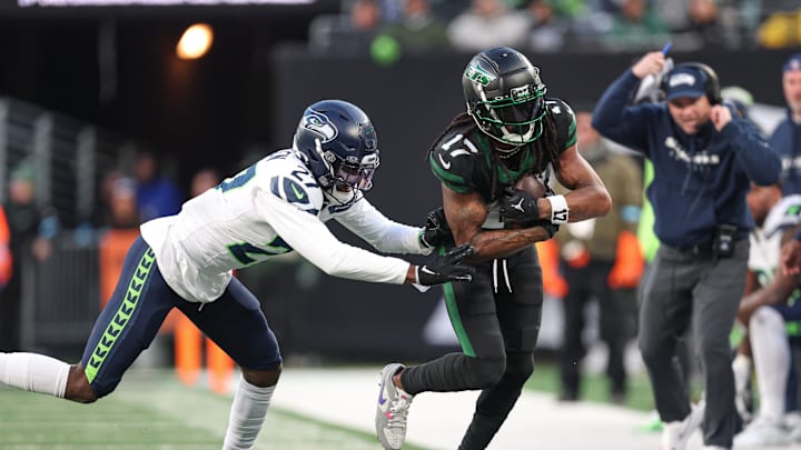 Dec 1, 2024; East Rutherford, New Jersey, USA; New York Jets wide receiver Davante Adams (17) is tackled by Seattle Seahawks cornerback Riq Woolen (27) during the second half at MetLife Stadium. Mandatory Credit: Vincent Carchietta-Imagn Images
