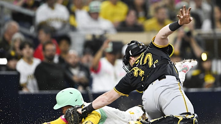 May 30, 2025; San Diego, California, USA; San Diego Padres first baseman Luis Arraez (4) scores ahead on the tag on Pittsburgh Pirates catcher Henry Davis (32) during the sixth inning at Petco Park. Mandatory Credit: Denis Poroy-Imagn Images