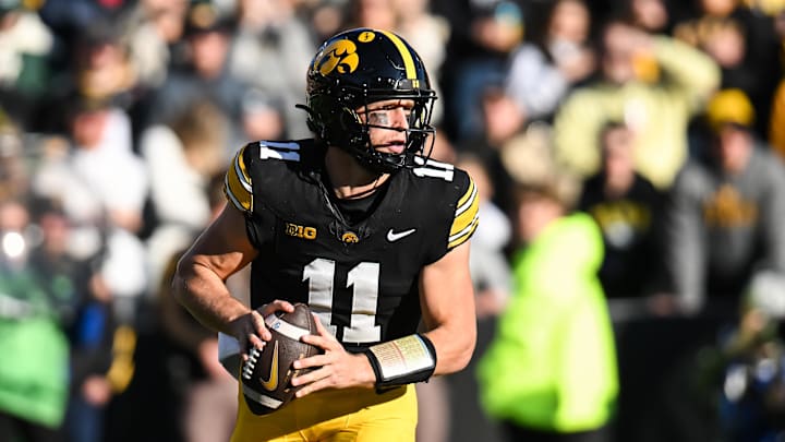 Nov 22, 2025; Iowa City, Iowa, USA; Iowa Hawkeyes quarterback Mark Gronowski (11) rolls out to throws a pass against the Michigan State Spartans during the first quarter at Kinnick Stadium. Mandatory Credit: Jeffrey Becker-Imagn Images