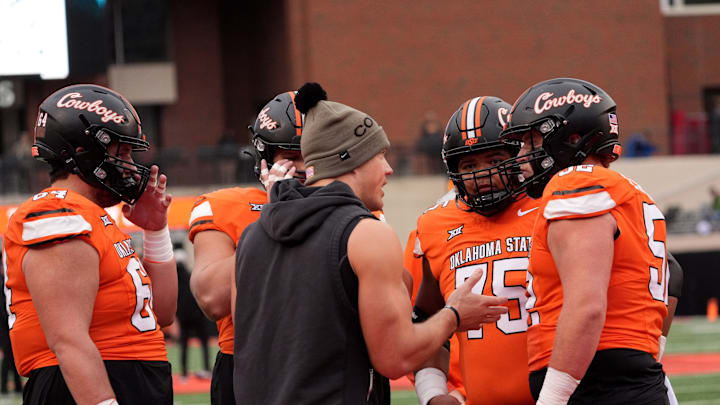 Oklahoma State Offensive Line coach Cooper Bassett talks with players before the college football game between the Oklahoma State Cowboys and the Iowa State Cyclones at Boone Pickens Stadium in Stillwater, Okla., Saturday Nov. 29, 2025.