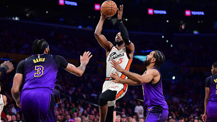 Dec 23, 2024; Los Angeles, California, USA; Detroit Pistons guard Malik Beasley (5) shoots against Los Angeles Lakers forward Anthony Davis (3) and guard Gabe Vincent (7) during the first half at Crypto.com Arena. Mandatory Credit: Gary A. Vasquez-Imagn Images