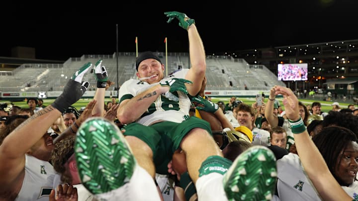 Record-breaking USF receiver Sean Atkins gets a lift from his happy teammates following the Bulls' five-overtime win in the Hawaii Bowl