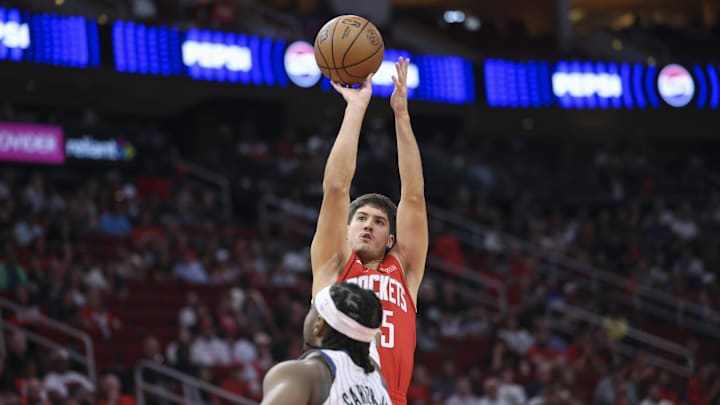 Nov 16, 2025; Houston, Texas, USA; Houston Rockets guard Reed Sheppard (15) shoots the ball over Orlando Magic center Wendell Carter Jr. (34) during the second quarter at Toyota Center. Mandatory Credit: Troy Taormina-Imagn Images
