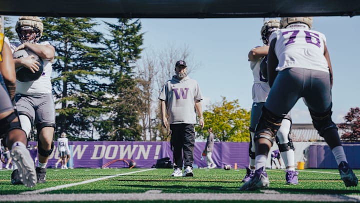 Husky offensive coordinator Brennan Carroll puts his offensive linemen through a drill.