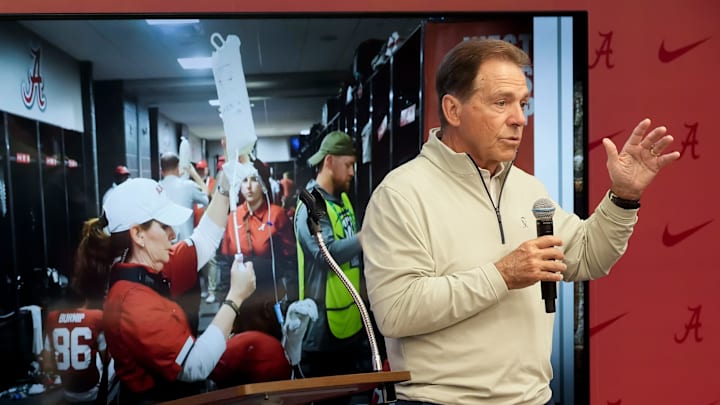 Feb 28, 2025; Birmingham, AL, USA; The University of Alabama celebrated the retirement of Dr. Ginger Gilmore from the athletic training staff Friday at Bryant-Denny Stadium. Nick Saban speaks in front of a photograph of Gilmore administering IV fluids. Feb 28, 2025; Birmingham, AL, USA; The University of Alabama celebrated the retirement of Dr. Ginger Gilmore from the athletic training staff Friday at Bryant-Denny Stadium. Nick Saban speaks in front of a photograph of Gilmore administering IV fluids.