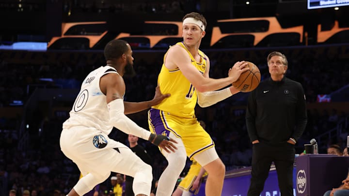 Feb 27, 2025; Los Angeles, California, USA; Los Angeles Lakers guard Austin Reaves (15) looks to pass against Minnesota Timberwolves guard Mike Conley (10) during the second quarter at Crypto.com Arena. Mandatory Credit: Jason Parkhurst-Imagn Images