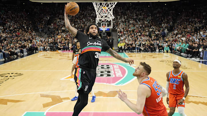 Dec 23, 2025; San Antonio, Texas, USA; San Antonio Spurs forward Julian Champagnie (30) goes up for a dunk over Oklahoma City Thunder center Isaiah Hartenstein (55) during the second half at Frost Bank Center. Mandatory Credit: Scott Wachter-Imagn Images Dec 23, 2025; San Antonio, Texas, USA; San Antonio Spurs forward Julian Champagnie (30) goes up for a dunk over Oklahoma City Thunder center Isaiah Hartenstein (55) during the second half at Frost Bank Center. Mandatory Credit: Scott Wachter-Imagn Images