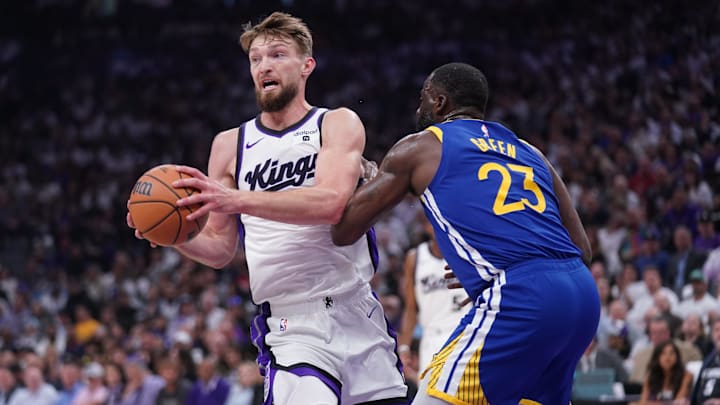 Apr 16, 2024; Sacramento, California, USA; Sacramento Kings forward Domantas Sabonis (10) looks to pass the ball next to Golden State Warriors forward Draymond Green (23) in the first quarter during a play-in game of the 2024 NBA playoffs at the Golden 1 Center. Mandatory Credit: Cary Edmondson-Imagn Images