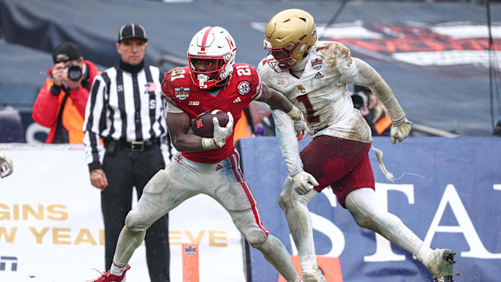 Dec 28, 2024; Bronx, NY, USA; Nebraska Cornhuskers running back Emmett Johnson (21) scores a touchdown as Boston College Eagles linebacker Daveon Crouch (1) defends during the second half at Yankee Stadium. Mandatory Credit: Vincent Carchietta-Imagn Images