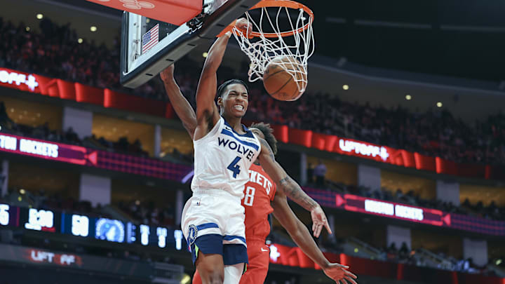 Feb 21, 2025; Houston, Texas, USA; Minnesota Timberwolves guard Rob Dillingham (4) dunks the ball as Houston Rockets forward Jae'Sean Tate (8) defends during the third quarter at Toyota Center. Mandatory Credit: Troy Taormina-Imagn Images