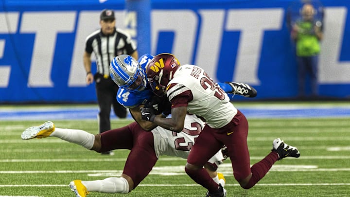 Washington Commanders safety Percy Butler and cornerback Marshon Lattimore tackle Detroit Lions receiver Amon-Ra St. Brown