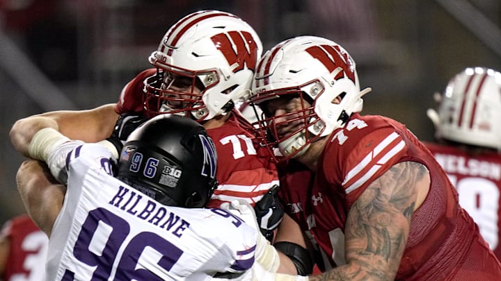 Wisconsin offensive lineman Riley Mahlman (71) and offensive lineman Michael Furtney (74) block Northwestern defensive lineman Michael Kilbane (96) during the fourth quarter of their game Saturday, November 11, 2023 at Camp Randall Stadium in Madison, Wisconsin. Northwestern beat Wisconsin 24-10.