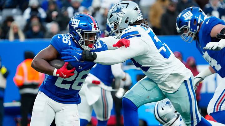 New York Giants running back Devin Singletary (26) tries to run past Dallas Cowboys defensive end Sam Williams (54), Sunday, January 4, 2026, in East Rutherford.