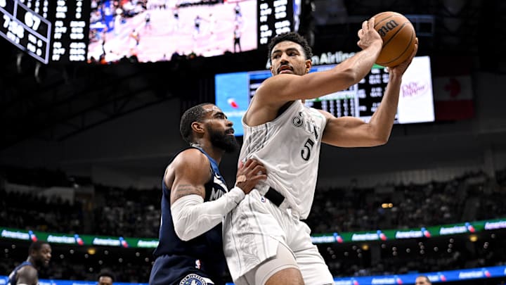 Jan 22, 2025; Dallas, Texas, USA; Dallas Mavericks guard Quentin Grimes (5) grabs a rebound in front of Minnesota Timberwolves guard Mike Conley (10) during the second half at the American Airlines Center. Mandatory Credit: Jerome Miron-Imagn Images