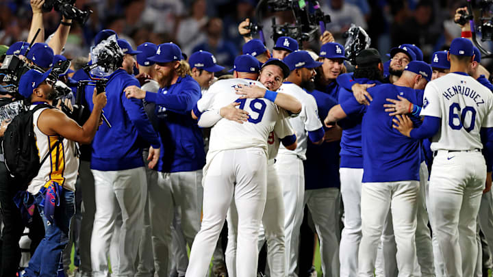 Oct 20, 2024; Los Angeles, California, USA; Los Angeles Dodgers third base Max Muncy (13) hugs pitcher Blake Treinen (49) after beating the New York Mets during game six of the NLCS for the 2024 MLB playoffs at Dodger Stadium. Mandatory Credit: Jason Parkhurst-Imagn Images