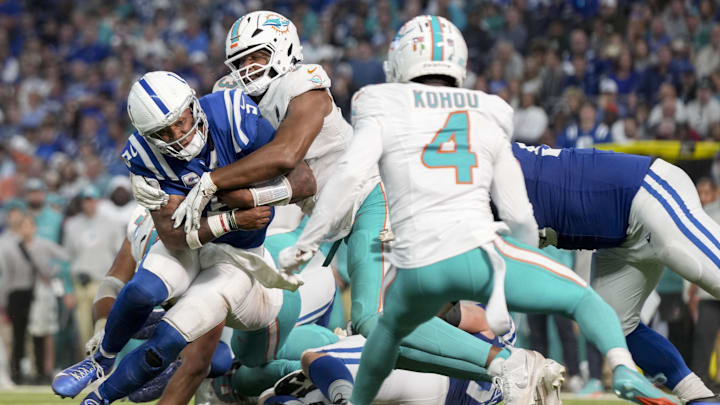 Indianapolis Colts quarterback Anthony Richardson (5) is wrapped up by Miami Dolphins defensive tackle Calais Campbell (93) during a game against the Miami Dolphins at Lucas Oil Stadium.