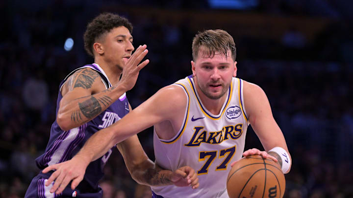 Dec 28, 2025; Los Angeles, California, USA;  Los Angeles Lakers guard Luka Doncic (77) is defended by Sacramento Kings guard Nique Clifford (5) in the second half at Crypto.com Arena. Mandatory Credit: Jayne Kamin-Oncea-Imagn Images