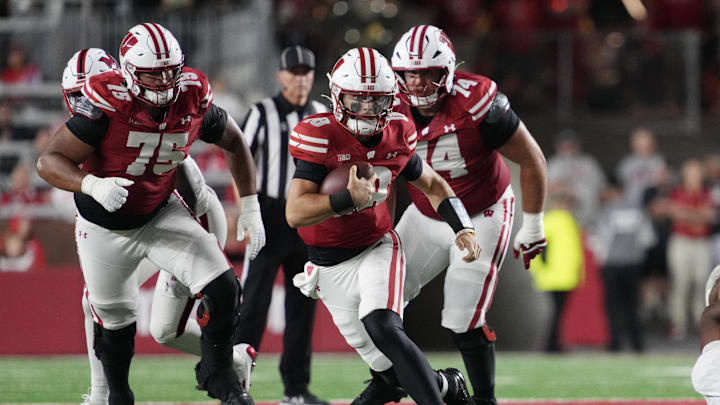 Aug 28, 2025; Madison, Wisconsin, USA;  Wisconsin Badgers quarterback Danny O'Neil (18) rushes with the football during the second quarter against the Miami (OH) RedHawks at Camp Randall Stadium. Mandatory Credit: Jeff Hanisch-Imagn Images