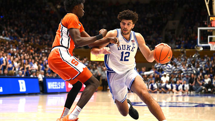Feb 16, 2026; Durham, North Carolina, USA;  Duke Blue Devils forward Cameron Boozer (12) brings the ball around  Syracuse Orange forward Sadiq White Jr. (0) during the second half at Cameron Indoor Stadium. Mandatory Credit: Zachary Taft-Imagn Images