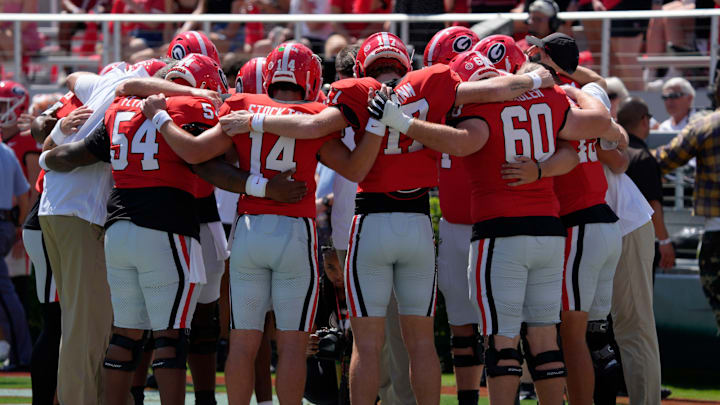 Georgia quarterback Gunner Stockton (14) and linemen pray during warms up before the start of a NCAA college football game against Marshall in Athens, Ga., on Saturday, August. 30, 2025.