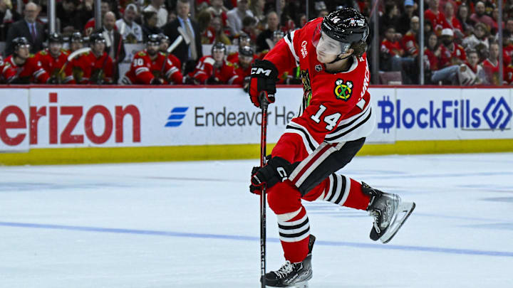 Mar 30, 2025; Chicago, Illinois, USA;  Chicago Blackhawks defenseman Kevin Korchinski (14) shoots against the Utah Hockey Club during the first period at United Center. Mandatory Credit: Matt Marton-Imagn Images