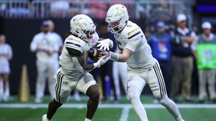 Oct 19, 2024; Atlanta, Georgia, USA; Georgia Tech Yellow Jackets running back Jamal Haynes (11) takes a handoff from quarterback Zach Pyron (5) against the Notre Dame Fighting Irish in the first quarter at Mercedes-Benz Stadium. Mandatory Credit: Brett Davis-Imagn Images