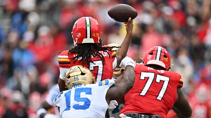 Maryland Terrapins quarterback Malik Washington (7) is hit from behind just as he throws by UCLA Bruins defensive line Sahir West (15) in the first half at SECU Stadium. 