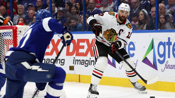 Jan 28, 2025; Tampa, Florida, USA; Chicago Blackhawks left wing Nick Foligno (17) passes the puck as Tampa Bay Lightning defenseman Victor Hedman (77) defends during the second period at Amalie Arena. Mandatory Credit: Kim Klement Neitzel-Imagn Images