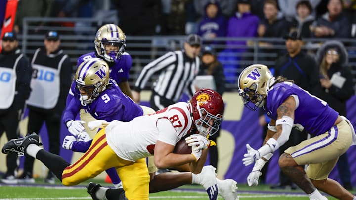 Nov 2, 2024; Seattle, Washington, USA; Washington Huskies cornerback Thaddeus Dixon (9) and safety Kamren Fabiculanan (13) stop USC Trojans tight end Lake McRee (87) just short of the end zone following a reception by McRee during the second quarter at Alaska Airlines Field at Husky Stadium. Nov 2, 2024; Seattle, Washington, USA; Washington Huskies cornerback Thaddeus Dixon (9) and safety Kamren Fabiculanan (13) stop USC Trojans tight end Lake McRee (87) just short of the end zone following a reception by McRee during the second quarter at Alaska Airlines Field at Husky Stadium.
