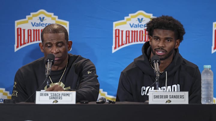 Dec 28, 2024; San Antonio, TX, USA; Colorado Buffaloes head coach Deion Sanders and quarterback Shedeur Sanders (2) talk with the media after the game against the Brigham Young Cougars at Alamodome.  