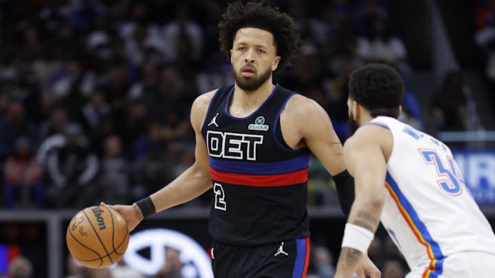Mar 15, 2025; Detroit, Michigan, USA;  Detroit Pistons guard Cade Cunningham (2) dribbles defended by Oklahoma City Thunder forward Kenrich Williams (34) in the first half at Little Caesars Arena. Mandatory Credit: Rick Osentoski-Imagn Images