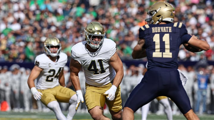 Oct 26, 2024; East Rutherford, New Jersey, USA; Notre Dame Fighting Irish defensive lineman Donovan Hinish (41) pass rushes Navy Midshipmen quarterback Blake Horvath (11) during the first half at MetLife Stadium. Mandatory Credit: Vincent Carchietta-Imagn Images