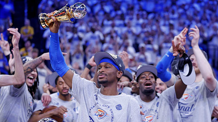May 28, 2025; Oklahoma City, Oklahoma, USA; Oklahoma City Thunder guard Shai Gilgeous-Alexander (2) celebrates with Magic Johnson West Conference Finals MVP trophy after defeating the Minnesota Timberwolves in game five to win the western conference finals for the 2025 NBA Playoffs at Paycom Center. Mandatory Credit: Alonzo Adams-Imagn Images