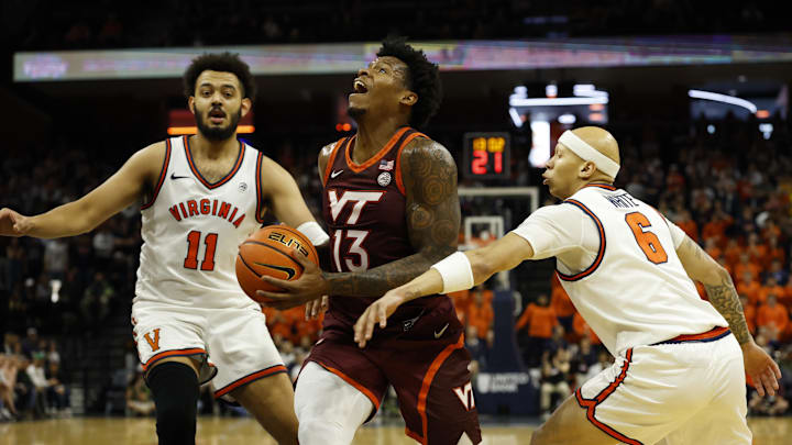 Mar 7, 2026; Charlottesville, Virginia, USA; Virginia Tech Hokies forward Amani Hansberry (13) drives to the basket as Virginia Cavaliers forward Devin Tillis (11) and Cavaliers guard Jacari White (6) defend in the first half at John Paul Jones Arena. Mandatory Credit: Geoff Burke-Imagn Images
