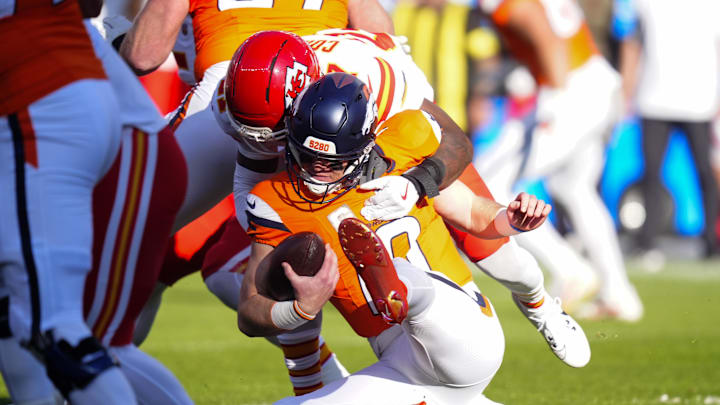 Nov 16, 2025; Denver, Colorado, USA;  Kansas City Chiefs safety Chamarri Conner (27) sacks Denver Broncos quarterback Bo Nix (10) during the first quarter of the game at Empower Field at Mile High. Mandatory Credit: Ron Chenoy-Imagn Images