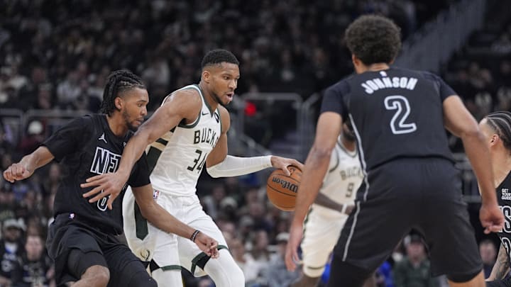 Jan 2, 2025; Milwaukee, Wisconsin, USA; Milwaukee Bucks forward Giannis Antetokounmpo (34) brings the ball up the court against Brooklyn Nets guard De'Anthony Melton (8) in the first half at Fiserv Forum. Mandatory Credit: Michael McLoone-Imagn Images