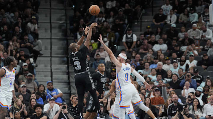 Nov 19, 2024; San Antonio, Texas, USA;  San Antonio Spurs guard Chris Paul (3) shoots over Oklahoma City Thunder guard Alex Caruso (9) in the second half at Frost Bank Center. Mandatory Credit: Daniel Dunn-Imagn Images