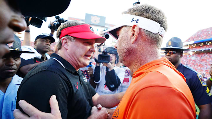 Sep 30, 2023; Auburn, Alabama, USA; Georgia Bulldogs head coach Kirby Smart meets Auburn Tigers head coach Hugh Freeze midfield following the Bulldogs 27-20 victory at Jordan-Hare Stadium. Mandatory Credit: John David Mercer-Imagn Images