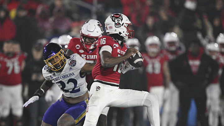 Dec 28, 2024; Annapolis, MD, USA;  North Carolina State Wolfpack quarterback CJ Bailey (16)] scrambles away from East Carolina Pirates linebacker Ryheem Craig (32) during the first half of the Go Bowling Military Bowl at Navy-Marine Corps Memorial Stadium. Mandatory Credit: Tommy Gilligan-Imagn Images