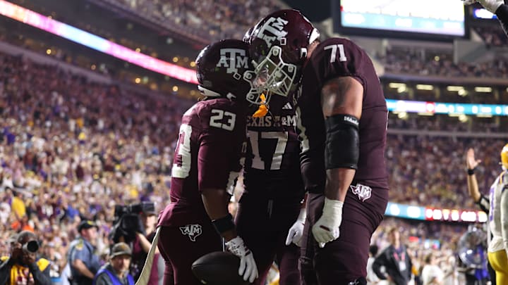Oct 25, 2025; Baton Rouge, Louisiana, USA; Texas A&M Aggies running back Jamarion Morrow (23) celebrates with offensive lineman Chase Bisontis (71) and tight end Theo Melin Ohrstrom (17) after a touchdown during the second half against the Louisiana State Tigers at Tiger Stadium. Mandatory Credit: Stephen Lew-Imagn Images