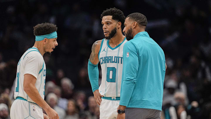 Feb 5, 2025; Charlotte, North Carolina, USA; Charlotte Hornets forward Miles Bridges (0), guard Seth Curry (30) talk with head coach Charles Lee during a free throw by Milwaukee Bucks during the second half at Spectrum Center. Mandatory Credit: Jim Dedmon-Imagn Images