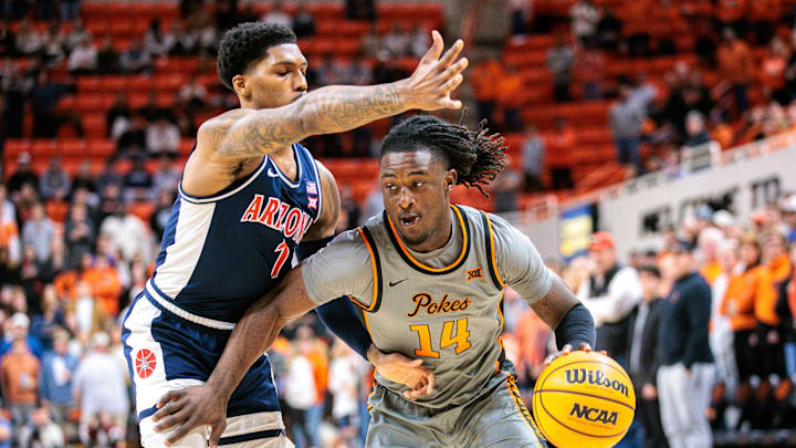 Jan 21, 2025; Stillwater, Oklahoma, USA; Oklahoma State Cowboys guard Jamyron Keller (14) drives around Arizona Wildcats guard Caleb Love (1) during the first half at Gallagher-Iba Arena. Mandatory Credit: William Purnell-Imagn Images Jan 21, 2025; Stillwater, Oklahoma, USA; Oklahoma State Cowboys guard Jamyron Keller (14) drives around Arizona Wildcats guard Caleb Love (1) during the first half at Gallagher-Iba Arena. Mandatory Credit: William Purnell-Imagn Images