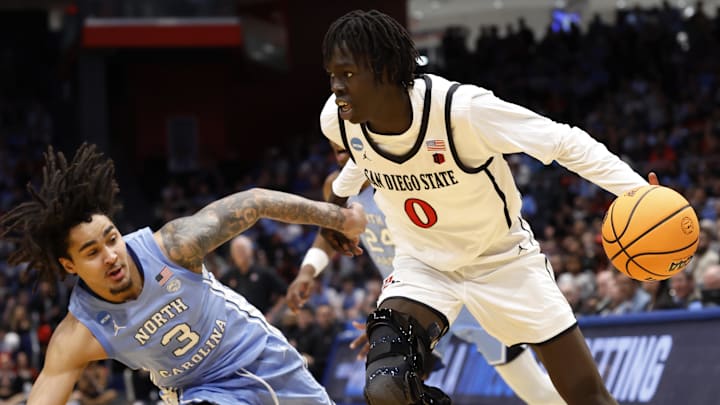Mar 18, 2025; Dayton, OH, USA; San Diego State Aztecs forward Magoon Gwath (0) dribbles the ball defended by North Carolina Tar Heels guard Elliot Cadeau (3) in the first half at UD Arena. Mandatory Credit: Rick Osentoski-Imagn Images