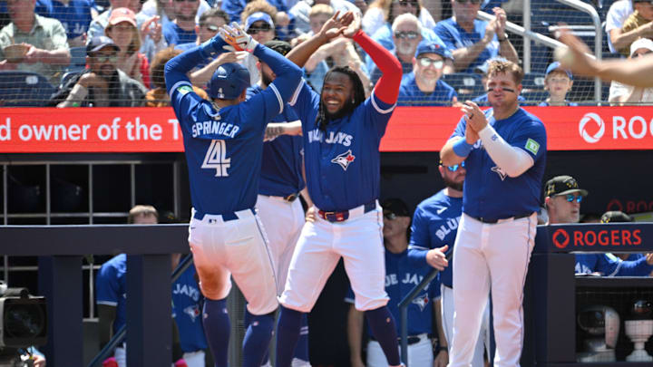 May 19, 2024; Toronto, Ontario, CAN;   Toronto Blue Jays right fielder George Springer (4) is greeted at the dugout by first baseman Vladimir Guerrero Jr. (27) an designated hitter Daniel Vogelbach (20) after scoring against the Tampa Bays Rays in the fourth inning at Rogers Centre.