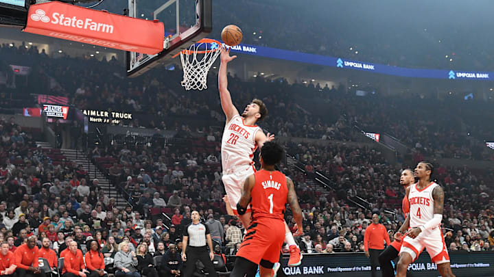 Jan 18, 2025; Portland, Oregon, USA;  Houston Rockets center Alperen Sengun (28) drives to the tool for a layup against Portland Trail Blazers guard Anfernee Simons (1) during the first half at Moda Center. Mandatory Credit: Brian Murphy-Imagn Images