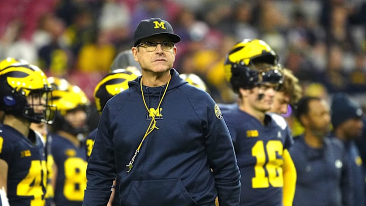 Michigan coach Jim Harbaugh walks the sideline during the warmups prior to his team's game against