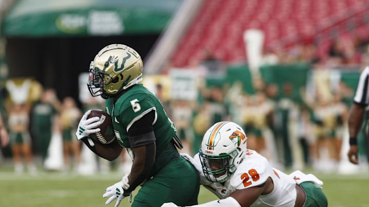 Sep 9, 2023; Tampa, Florida, USA; South Florida Bulls running back Nay'Quan Wright (5) outruns a tackle from Florida A&M Rattlers linebacker Johnny Chaney Jr. (28) during the first quarter at Raymond James Stadium. Mandatory Credit: Morgan Tencza-USA TODAY Sports